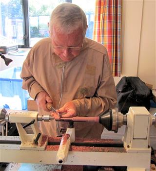 Keith Leonard turning part of a drop spindle